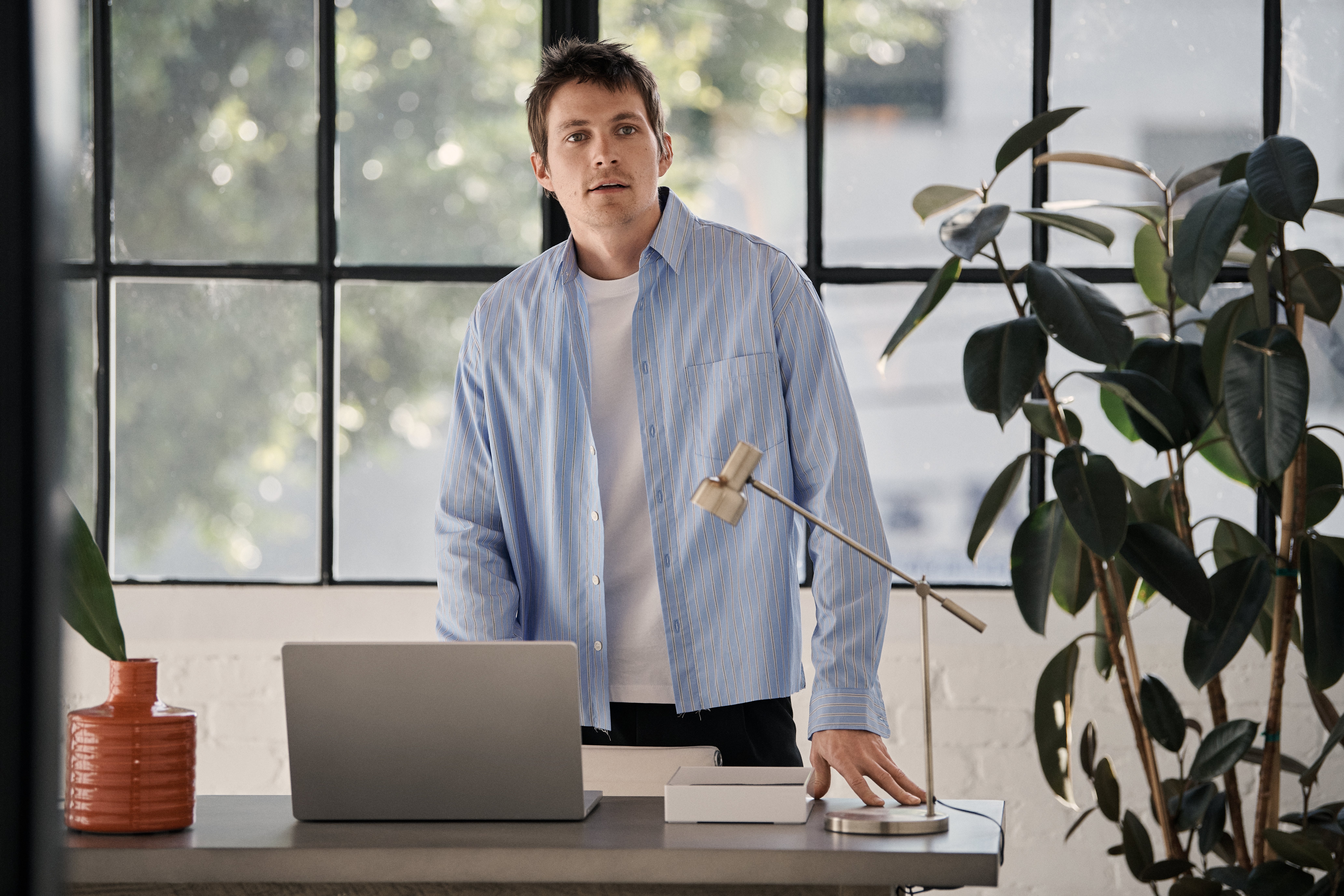 Man standing in office with laptop