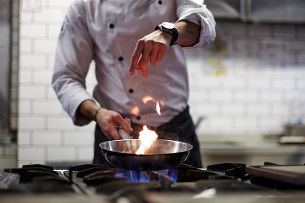 Background image of a restaurant wordpress theme showing chef in kitchen
