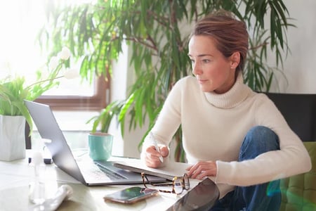 woman at desk procrastinating while writing