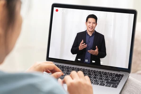 A marketing agency client reviews a recorded virtual marketing campaign pitch from a marketer.