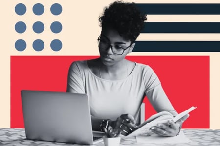 person looking at computer while reading web design books