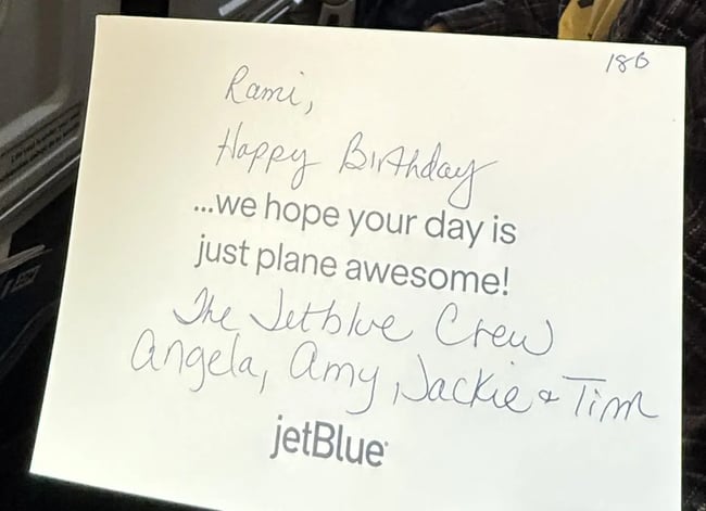 Handwritten birthday card from JetBlue crew signed by Angela, Amy, Jackie, and Tim wishing passenger happy birthday