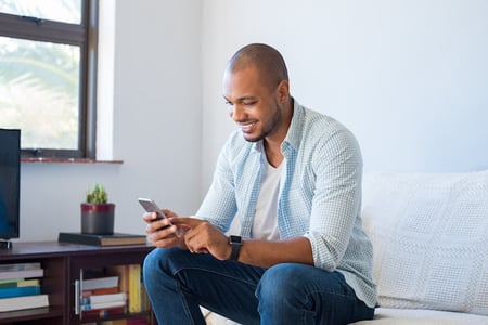 man using a smartphone to view a wordpress website built with a wordpress facebook theme