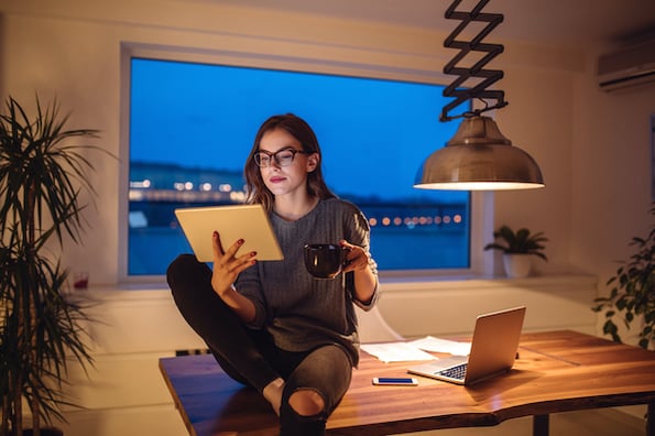 woman using a tablet in her home office to browser for the best job board wordpress themes