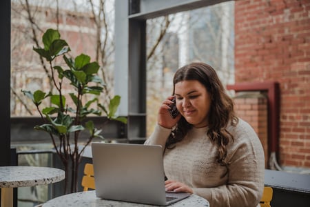 Person seeking a WordPress SMS plugin discusses her options with a colleague. 
