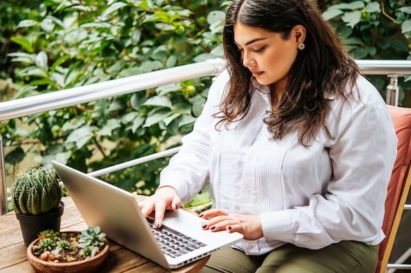 woman using a computer outside to browser for wordpress themes with visual composer