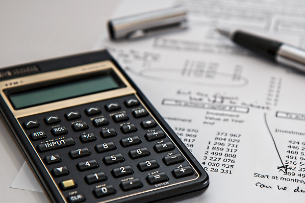 Tableau de financement imprimé posé à côté d'une calculatrice et d'un stylo à plume
