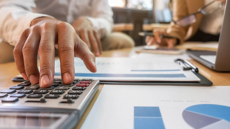 Personen-berechnen-Marketingbudget-mit-Taschenrechner-und-Notizen