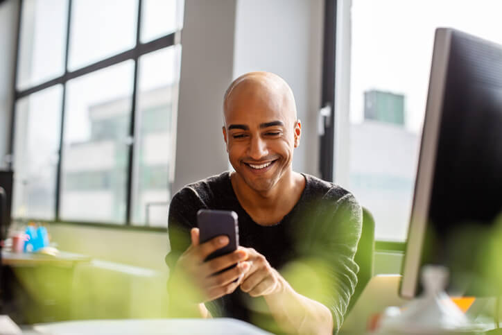 Mann-nutzt-Smartphone-für-Social-Media-Management-im-Unternehmen