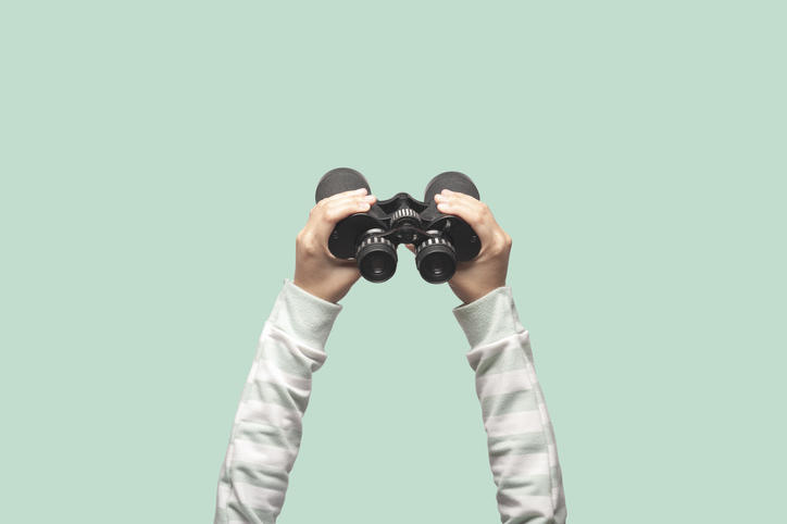 Person-hält-Fernglas-für-visuelle-Suche-hoch