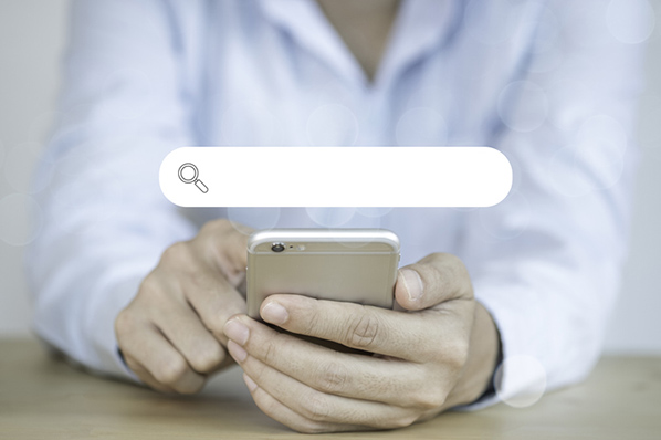 Person sucht auf Handy mit booleschen Operatoren