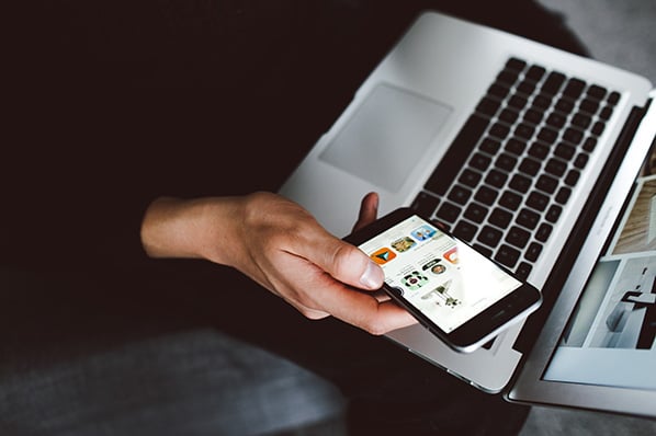 Frau beschäftigt sich mit digitalem Marketing am Smartphone und Laptop