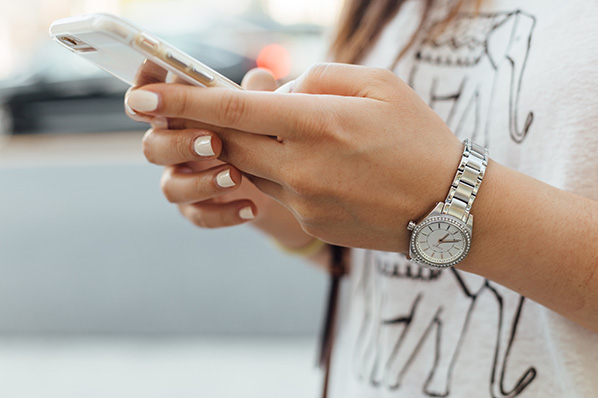 Nahaufnahme Frau erstellt Facebook Carousel Ad am Smartphone