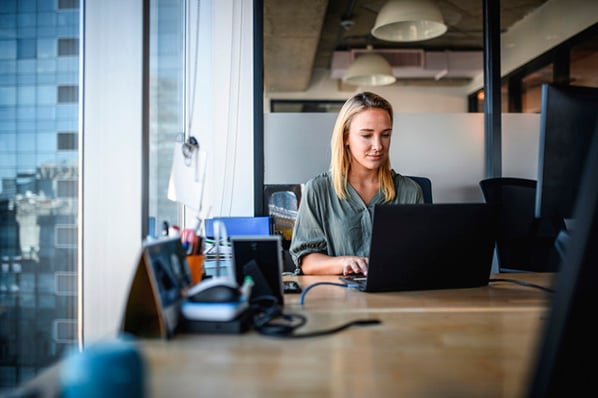 Frau am Laptop optimiert Website, um Google Ranking zu verbessern