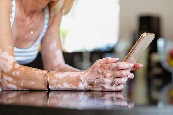 Nauaufnahme Frau auf Glastisch mit Smartphone erstellt Instagram-Posts