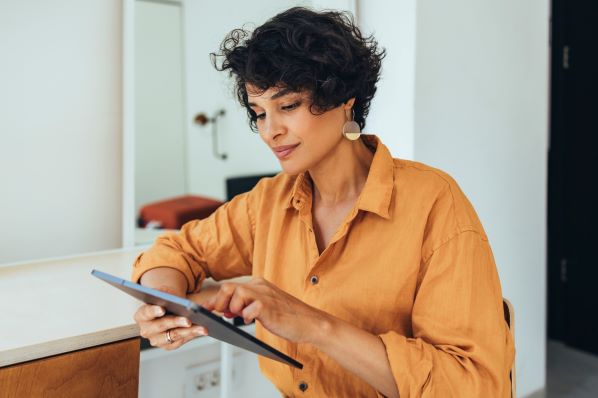 Frau erstellt Rich Pins auf Pinterest mit Tablet