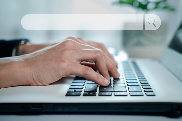 Finger auf Tastatur mit Suchleiste drueber symbolisieren semantische Suchmaschine