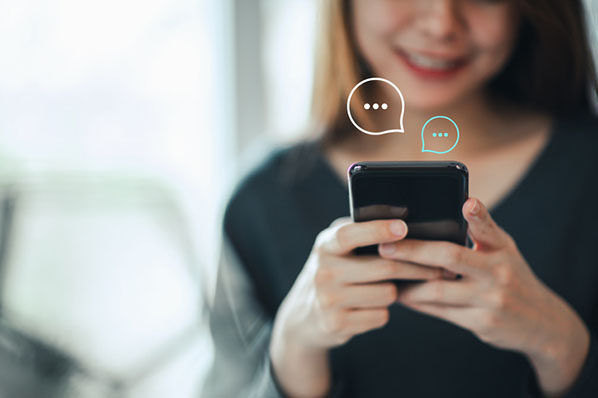 Frau erstellt eine WhatsApp Broadcast Liste am Smartphone