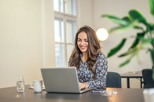 woman using a laptop to install a WordPress shortcode plugin