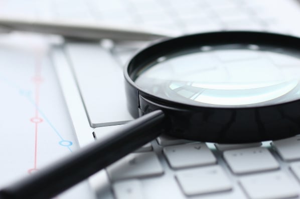 loupe sur un clavier, documents résultats audit