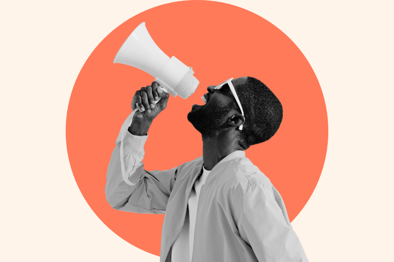 A woman smiles and shouts into a megaphone