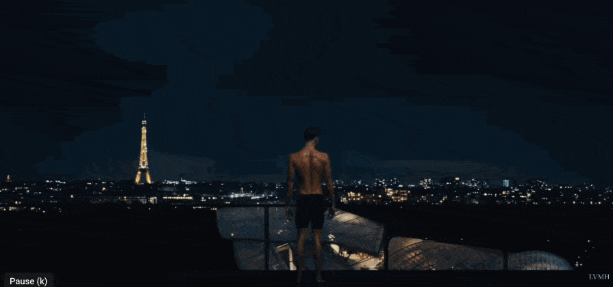 Animated GIF excerpt from the LVMH ad The Rooftops. Tilting shot from behind an athlete overlooking Paris at night.
