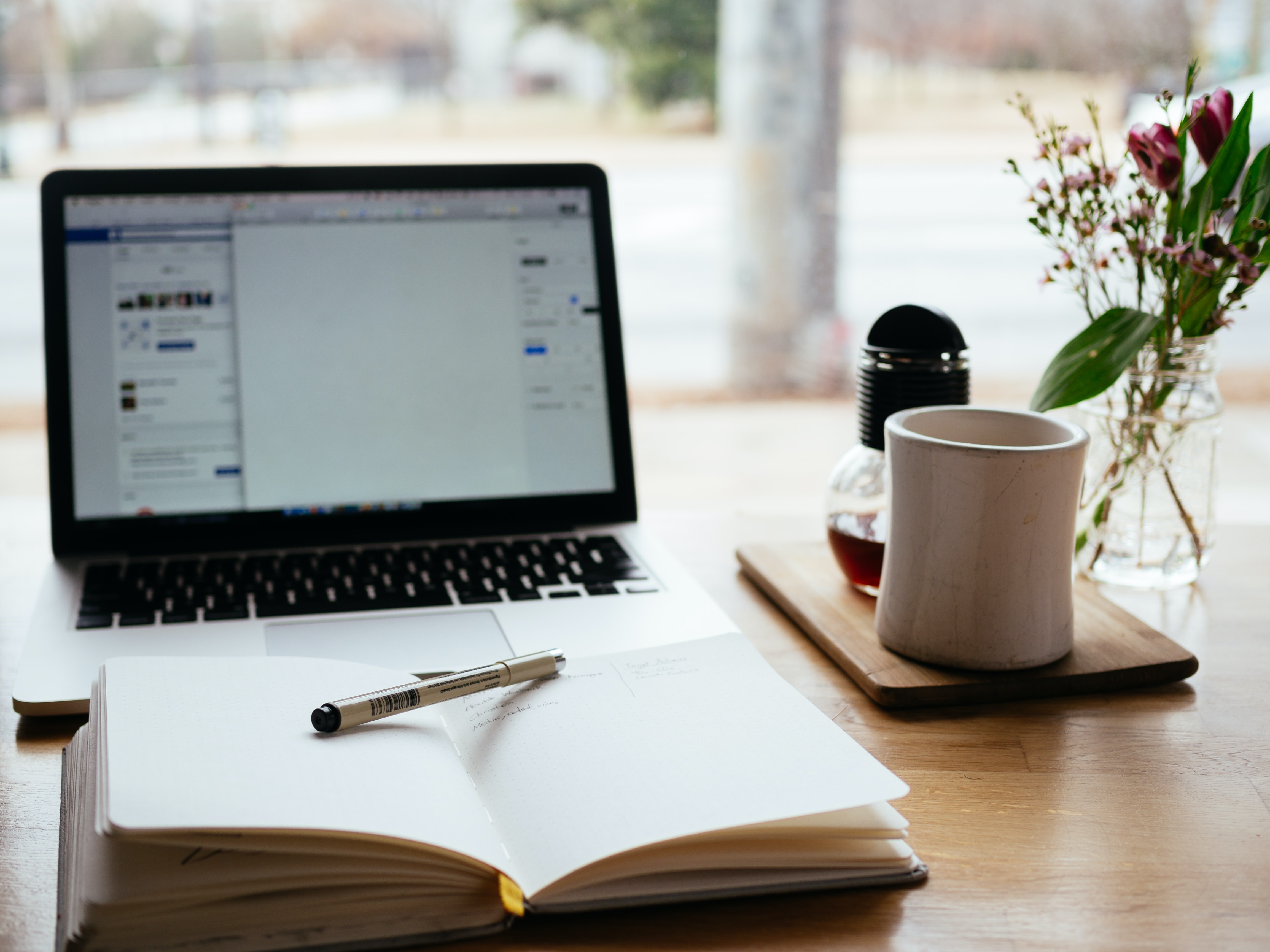 bureau avec bloc note, pc et café