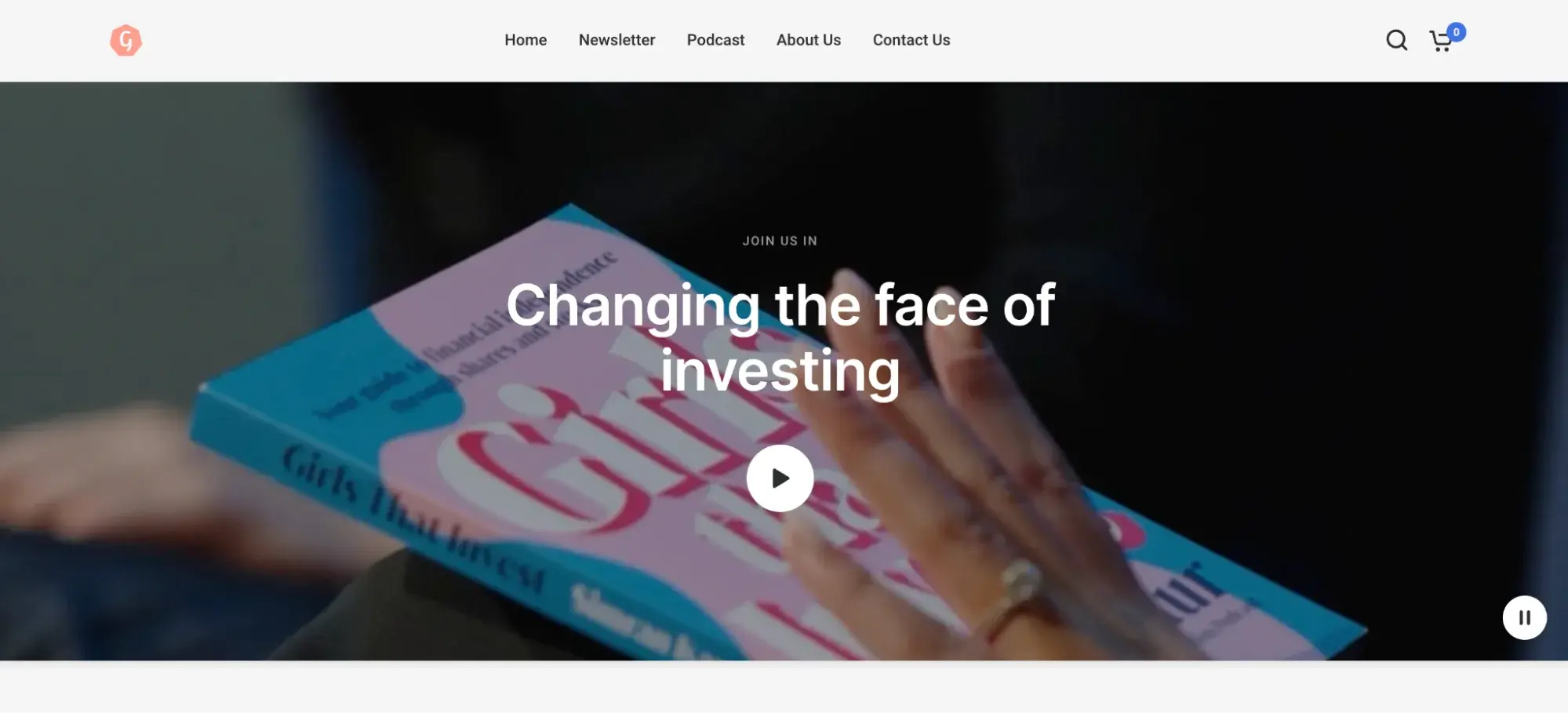 Website header for a company named Girls That Invest. It shows a hand holding a book titled Girls That Invest with text overlaid saying Changing the face of investing and a play button.