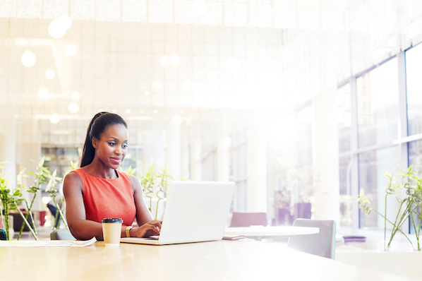 Businesswoman in a modern office using her laptop for GraphQL vs. REST API