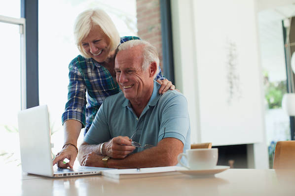 two people using a laptop at a table to install and use gravity forms in wordpress