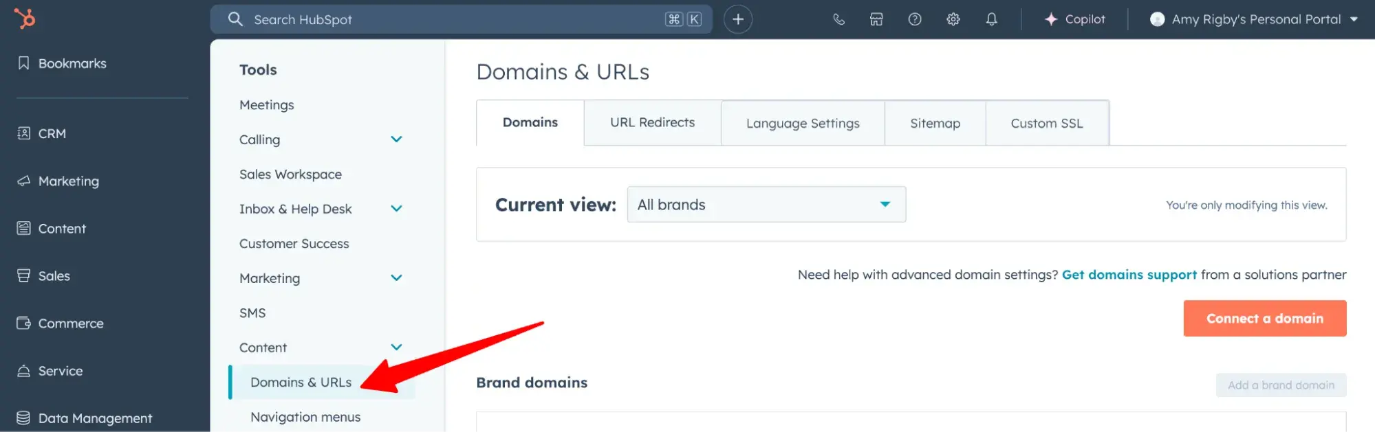 red arrow pointing to domains & urls in the hubspot dashboard
