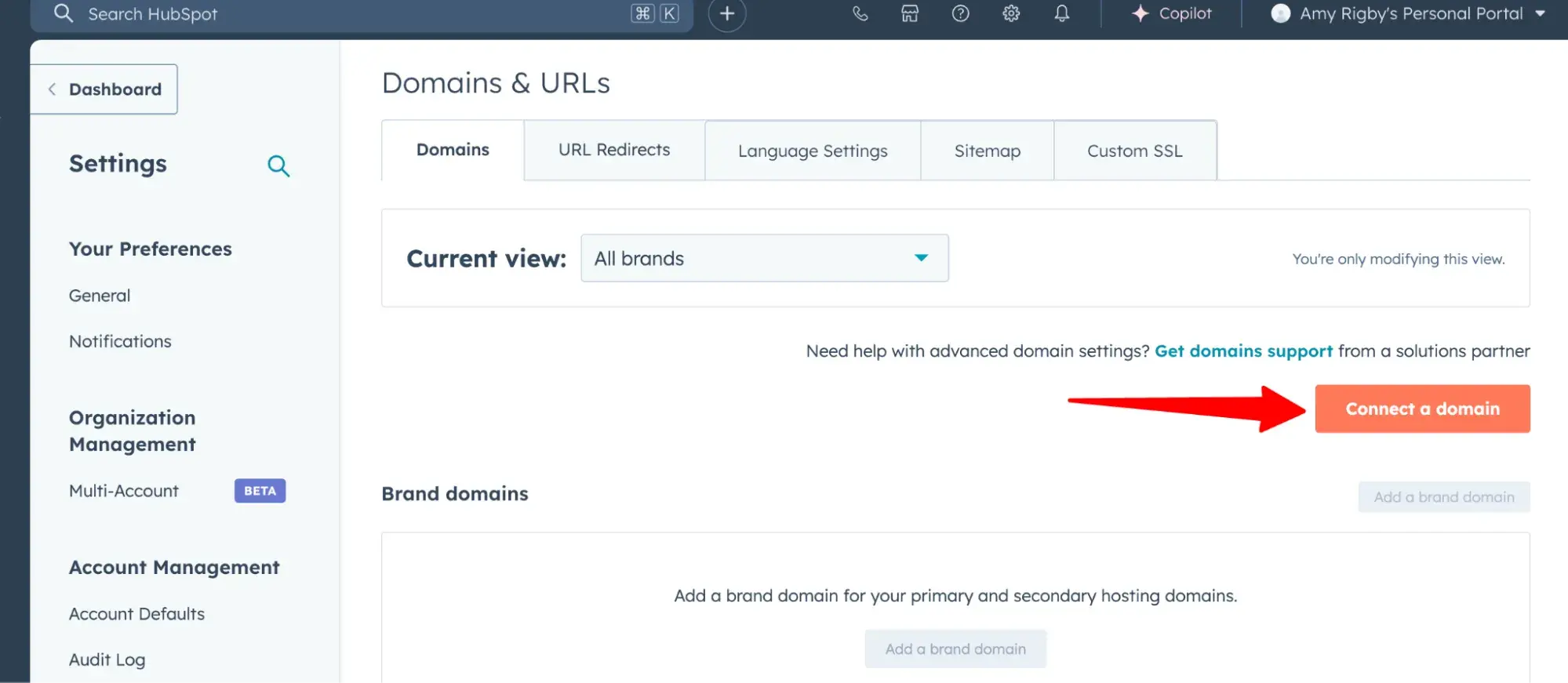 red arrow pointing to the orange “connect a domain” button in the hubspot dashboard
