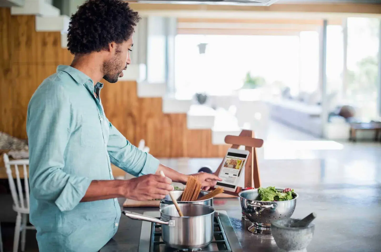 person using a wordpress food blog theme on their tablet while cooking 