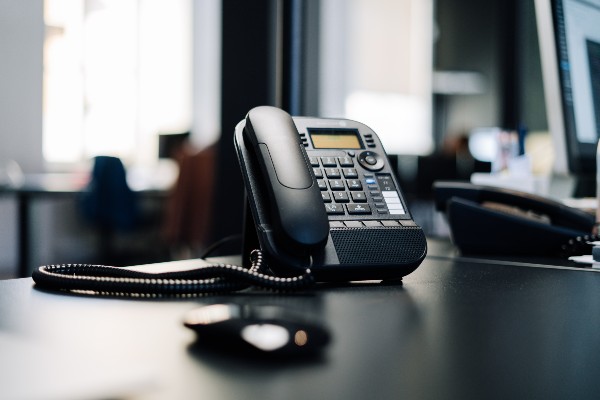 téléphone fixe noir posé sur un bureau