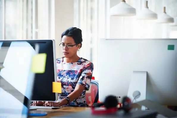 woman using a computer to review why not to use nulled wordpress themes and plugins