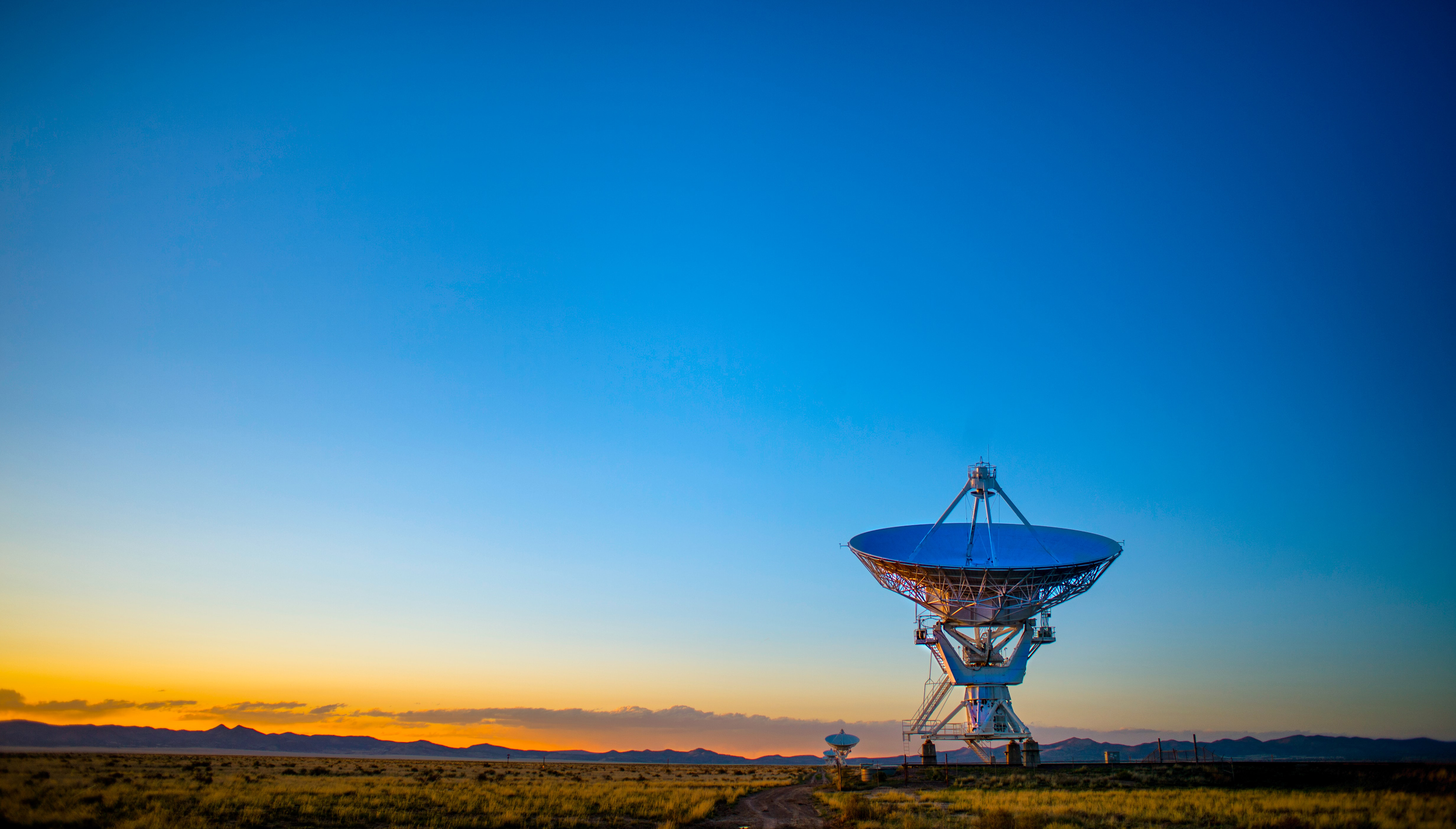 Satellite pointed up toward sky at sunrise.