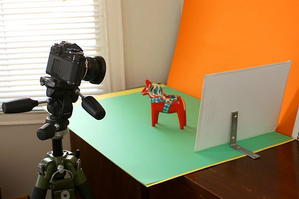 Rebatedor separado posicionado atrás de um cavalo em miniatura para fotografar o produto com luz difusa